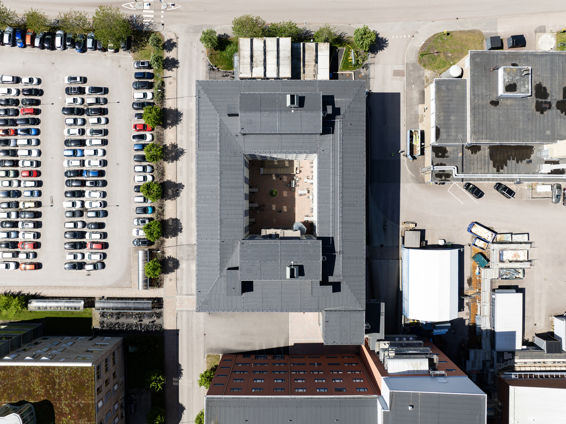 Rakt uppifrån-vy över kontorsmoduler från Expandia vid Centralsjukhuset i Karlstad. De modulära kontorsbyggnaderna bildar en sluten gård i mitten och omges av parkering, servicebyggnader och sjukhusets övriga fastigheter, vilket visar hur Expandias flexibla kontorsmoduler är integrerade i sjukhusområdet.