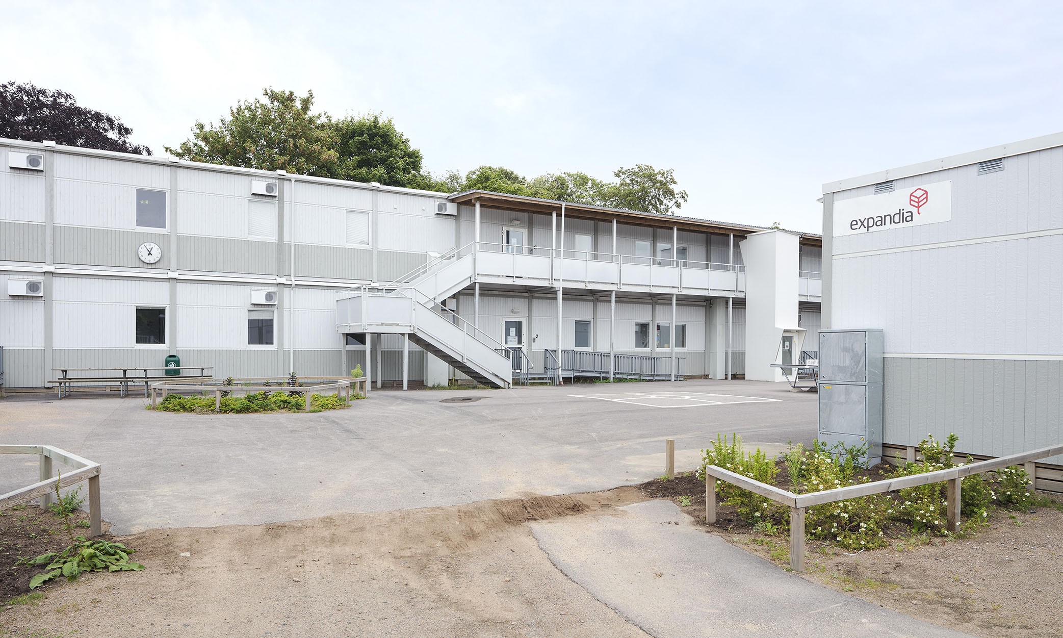 Skolmiljö i modullösning från Expandia vid Rebbelberga skola i Ängelholm, med två våningsplan, utvändiga trappor, entréer och gårdsyta mellan modulerna.
