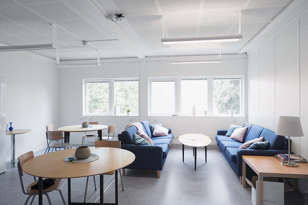 Invändigt rum i skolmodullösning från Expandia vid Rebbelberga skola i Ängelholm, med soffgrupper, bord, stolar och stora fönster som ger ett ljust och trivsamt rum.