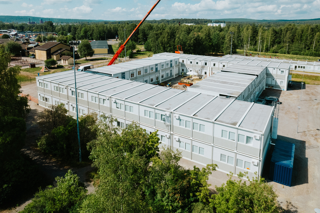 Drönarbild över Herrhagsgården vård- och omsorgsboende i Falun, bestående av en ljus modulbyggnad i två plan. Boendet är uppbyggt av sammankopplade moduler och omges av grönska. Modullösningen hyrs från Expandia.