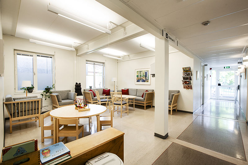 Ljust väntrum i vårdcentral uppförd med moduler från Expandia, med soffgrupper, runda bord och korridor mot behandlingsrum.